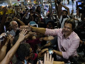 Fernando Haddad, who ran in the last presidential race backed by the Workers' Party, right, greets supporters during a protest against cuts in Brazil's public education sector at Cinelandia square, Rio de Janeiro, Brazil, Friday, May 10, 2019. Students and teachers gathered in the city's center Friday, taking a stand against the administration of fair-right President Jair Bolsonaro.