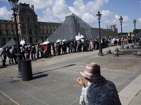 Tourists wait in line to visit the Louvre museum as it reopens, in Paris, Wednesday, May, 29, 2019. The world's most visited museum was closed on Monday after employees complained they were harassed by tourists waiting to see the Mona Lisa.