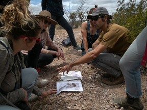 Scott Warren, (R), a volunteer for the humanitarian aid organization No More Deaths speaks with student volunteers delivering food and water along remote desert trails used by undocumented immigrants on May 10, 2019 near Ajo, Arizona.