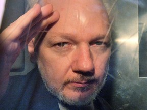 In this file photo taken on May 01, 2019, WikiLeaks founder Julian Assange gestures from the window of a prison van as he is driven out of Southwark Crown Court in London.