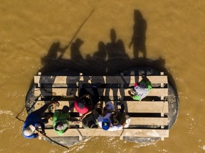Aerial picture showing migrants and residents using a makeshift raft to cross the Suchiate river from Tecun Uman in Guatemala to Ciudad Hidalgo in Chiapas State, Mexico, on June 6, 2019.