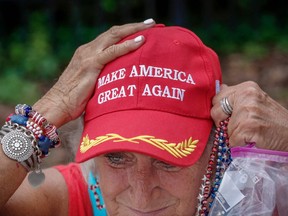 A supporter of U.S. President Donald Trump adjusts her cap as she waits along one of the main streets outside the Amway Center on June 17, 2019 some 40 hours before a Trump campaign event in Orlando, Florida.