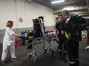 Firefighters and emergency workers assist a woman suffering from the heat in Tours, France on June 27, 2019, during a heatwave.