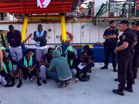 An image grab taken from a video released by Local Team shows migrants disembarking from the Sea-Watch 3 charity ship in Lampedusa, Sicily.