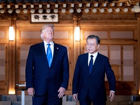 U.S. President Donald Trump and South Korea's President Moon Jae-in stand together before a working dinner at the tea house on the grounds of the presidential Blue House in Seoul.