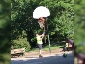 A screenshot of the video showing a man pulling down a basketball net.