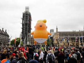 A giant balloon depicting U.S. President Donald Trump as an orange baby floats above anti-Trump demonstrators in Parliament Square outside the Houses of Parliament in London on June 4, 2019, on the second day of Trump's three-day State Visit to the U.K.