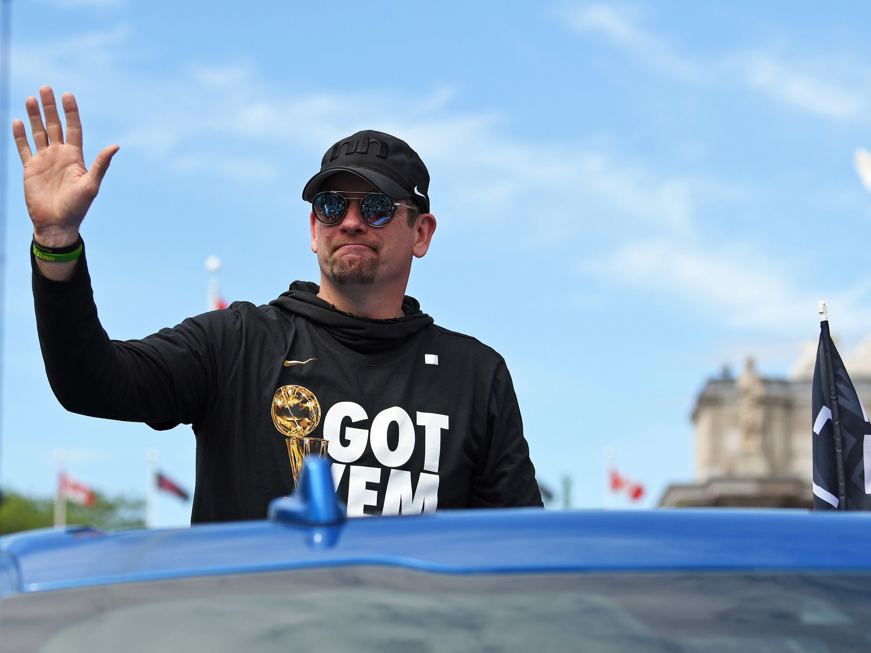 A man in black hat, sweater waves