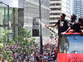 Toronto Raptors forward Pascal Siakam sprays the crowd with champagne as he celebrates during the 2019 Toronto Raptors Championship parade in Toronto on Monday, June 17, 2019.