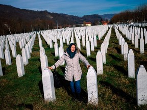 A woman mourns over a relative's grave at a cemetery and memorial for victims of the Bosnian genocide, near Srebrenica on Nov. 22, 2017.