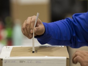 A voter casts a ballot at a polling station in Montreal, Quebec, Canada, on Monday, Oct. 1, 2018. Quebeckers go to the polls Monday to decide whether to try a new political party for the first time in nearly four decades, with the province's dairy industry suddenly under threat.
