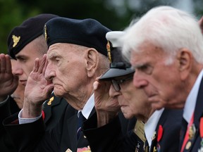 Canadian veterans of the Battle of Normandy and family members stand during a commemorative ceremony at the Commonwealth War Graves Commissions Beny-sur-Mer Canadian War Cemetery in Normandy on June 5, 2019, near Reviers, France.