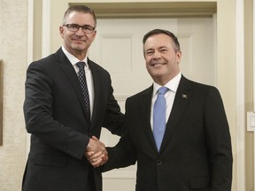 Alberta premier Jason Kenney shackles hands with Travis Toews, President of Treasury Board and Minister of Finance after being sworn into office in Edmonton on April 30, 2019. Alberta's finance minister says they will pass legislation if necessary to override collective bargaining agreements with unions and delay contractually mandated wage talks. The move would affect thousands of workers across the province, including nurses, hospital support staff, conservation officers, social workers, correctional officers, and the sheriffs who protect politicians in the legislature.