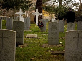A Royal Canadian Navy personnel pays his respects during a Remembrance Day ceremony at God's Acre Veteran's Cemetery in Victoria, B.C., on Sunday, November 11, 2018. A retail chain has stepped forward with an offer to cover the costs of Remembrance Day in Victoria, hours before city council was scheduled to debate funding for the annual ceremony.