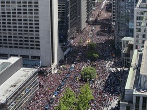 Fans cheer as the Toronto Raptors pass by during the Raptors Championship parade in Toronto on Monday, June 17, 2019. The City of Toronto is defending how police and paramedics dealt with a sick baby in the massive crowd that turned out for the Raptors NBA championship victory parade earlier this month.