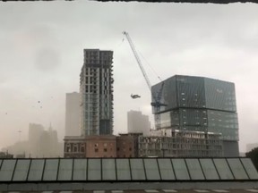 A construction crane sways before toppling amidst high winds in Dallas, Texas, U.S., June 9, 2019 in this still image taken from a social media video.