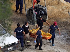 Members of Cyprus Special Disaster Response Unit carry a body retrieved after an investigation for possible bodies of victims of a suspected serial killer in Kokkinopezoula lake, also known as 'red lake,' near the village of Mitsero, Cyprus, May 5, 2019.