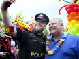 Ontario Premier Doug Ford poses for a photo with a York Regional Police officer at a Pride Parade in Newmarket, Ont., on June 15, 2019.