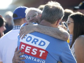 Minister of Economic Development, Job Creation and Trade and Chair of Cabinet Vic Fedeli (centre left) hugs a supporter during Ford Fest in Markham, Ont., on Saturday June 22, 2019.