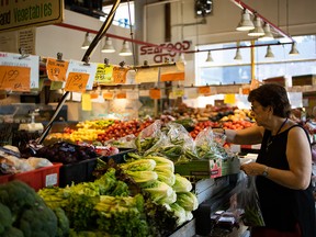 A shopper browses produce at the Granville Island Public Market in Vancouver on June 2, 2019.