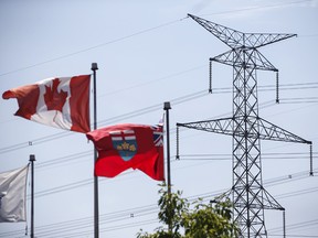 Canadian and Ontario flags fly in front of a Hydro One transmission tower in Toronto in a file photo from July 12, 2018.