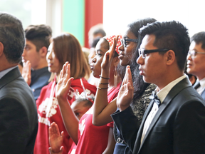 New Canadians are sworn in during a citizenship ceremony.