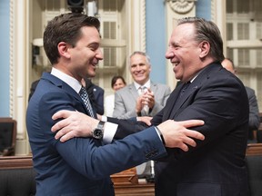 Quebec Minister of Immigration, Diversity and Inclusiveness Simon Jolin Barrette, left, is congratulated by Quebec Premier Francois Legault after they voted a legislation on secularism, at the National Assembly in Quebec City, Sunday, June 16, 2019.