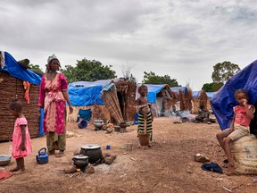 A Fulani woman poses while she prepares a meal for her children in an Internally Displaced People's (IDP) camp set up on the outskirts of Bamako on May 4, 2019.