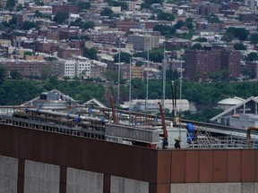 Officials stand on 787 7th Ave. a day after a helicopter crashed into the building in New York City, New York, U.S., June 11, 2019.