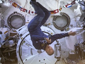 Canadian Space Agency astronaut David Saint-Jacques turns upside-down during his last press conference in orbit before returning to Earth on June 24, seen on a giant screen in Saint-Hubert, Que. on Wednesday, June 19, 2019.