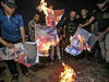 Palestinians in the Gaza Strip burn posters of U.S. President Donald Trump, Israeli Prime Minister Benjamin Netanyahu and King Hamad al-Khalifa of Bahrain on June 25, 2019, to protest against the U.S.-led Peace to Prosperity conference in Bahrain.
