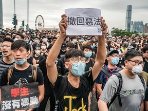 Protesters hold placards and shout slogans as they occupy a street outside the office of the Chief Executive Office on June 17, 2019, in Hong Kong.