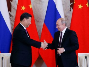 Russian President Vladimir Putin and his Chinese counterpart Xi Jinping shake hands after a signing ceremony following their talks at the Kremlin in Moscow on June 5, 2019.
