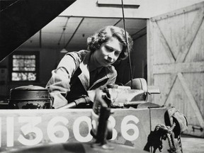 Princess Elizabeth, 18, takes the spark plugs out of a truck in April 1945.