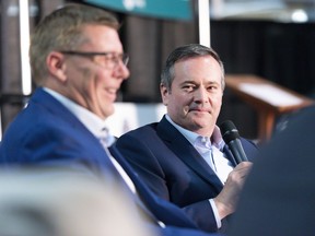 Saskatchewan Premier Scott Moe laughs as Alberta Premier Jason Kenney looks on during a joint panel discussion held in the Weyburn Curling Rink at the Saskatchewan Oil & Gas Show in Weyburn, Sask. on Wednesday June 5, 2019.