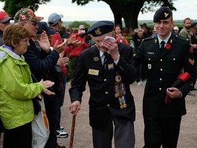 Richard Brown, a Canadian veteran of the Battle of Normandy, departs with his son Andy to the applause of visitors following a commemorative ceremony at the Commonwealth War Graves Commissions Beny-sur-Mer Canadian War Cemetery in Normandy on June 5, 2019, near Reviers, France.