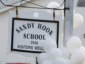 Balloons hang on a sign at the entrance to Sandy Hook Elementary School in Newtown, Conn., in a photo taken on Dec. 15, 2012, the day after a gunman shot and killed 26 people, including 20 children.