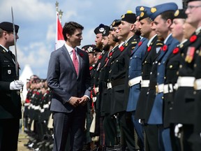 Prime Minister Justin Trudeau inspects an honour guard during the D-Day 75th Anniversary Canadian National Commemorative Ceremony at Juno Beach in Courseulles-Sur-Mer, France on Thursday, June 6, 2019.