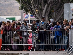 Asylum seekers queue for a turn for an asylum appointment with US authorities, at the US-Mexico El Chaparral crossing port in Tijuana, Baja California State, Mexico, on May 31, 2019.