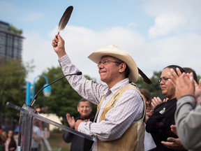 Coldwater Indian band Chief Lee Spahan raises an eagle feather after responding to a Federal Court of Appeal ruling on the Trans Mountain Pipeline expansion, at a news conference on Aug. 30, 2018.