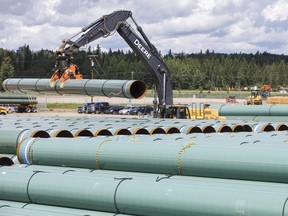 Pipe for the Trans Mountain pipeline is unloaded in Edson, Alta. on Tuesday June 18, 2019.