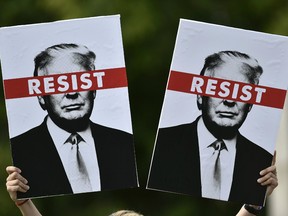 A protestor holds placards prior to the Scotland United Against Trump march through the streets of Edinburgh, Scotland on July 14, 2018, on the third day of US President Donald Trump's four-day UK visit.