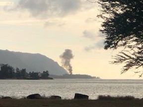 A plume of smoke rises after an airplane crash, seen from Kaiaka Bay Beach Park, in Haleiwa, Hawaii, U.S., June 21, 2019 in this image obtained from social media.