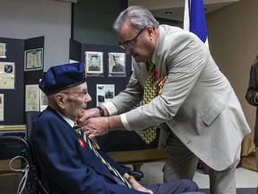 Bruno Burnichon of the French Consul in Winnipeg, on behalf of the French President, Emmanuel Macron, pins the Legion of Honour on Second World War Veteran Sir Ian Wilson at Deer Lodge Centre in Winnipeg on June 15, 2019.