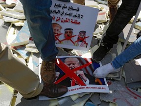 Palestinians stamp on protest signs showing the crossed-out faces of (left to right) Israeli Prime Minister Benjamin Netanyahu, US President Donald Trump, King Hamad al-Khalifa of Bahrain, and Saudi Crown Prince Mohammed bin Salman, with a caption above in Arabic reading "Palestine is not for sale, no to the conference of shame in Bahrain, the deal of the century will not pass", during the "Run for Freedom" marathon in Bethlehem in the occupied West Bank, on June 16, 2019 in protest against Trump's expected peace plan proposal.