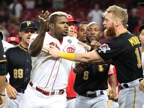 Yasiel Puig #66 of the Cincinnati Reds is restrained during a bench clearing altercation in the 9th inning of the game against the Pittsburgh Pirates at Great American Ball Park on July 30, 2019 in Cincinnati, Ohio.