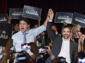 Canadian Prime Minister Justin Trudeau, left, raises the hand of Steven Guilbeault during an event to launch his candidacy for the Liberal party of Canada in Montreal, Wednesday, July 10, 2019. Guilbeault will run in the riding of Laurier-Sainte-Marie. (Graham Hughes/The Canadian Press via AP)