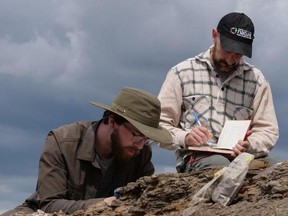 Tom Dudgeon (L) and Scott Rufalo of the Canadian Museum of Nature explore dinosaur country near Hilda, Alberta this summer. For story by Tom Spears. Photo by Pierre Poirier