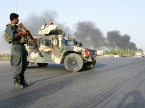 An Afghan police officer keeps watch near the site of a suicide car bomb blast in Kandahar, Afghanistan July 18, 2019.