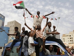 Sudanese protestors celebrate in the streets of Khartoum after ruling generals and protest leaders announced they have reached an agreement on the disputed issue of a new governing body on July 5, 2019.